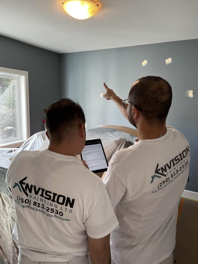 two Envision Painting team members inspecting paint job